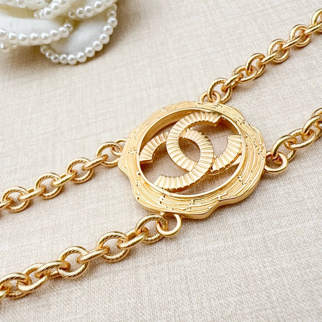 Gold-tone round interlocking CC centerpiece on a chain belt with curb links