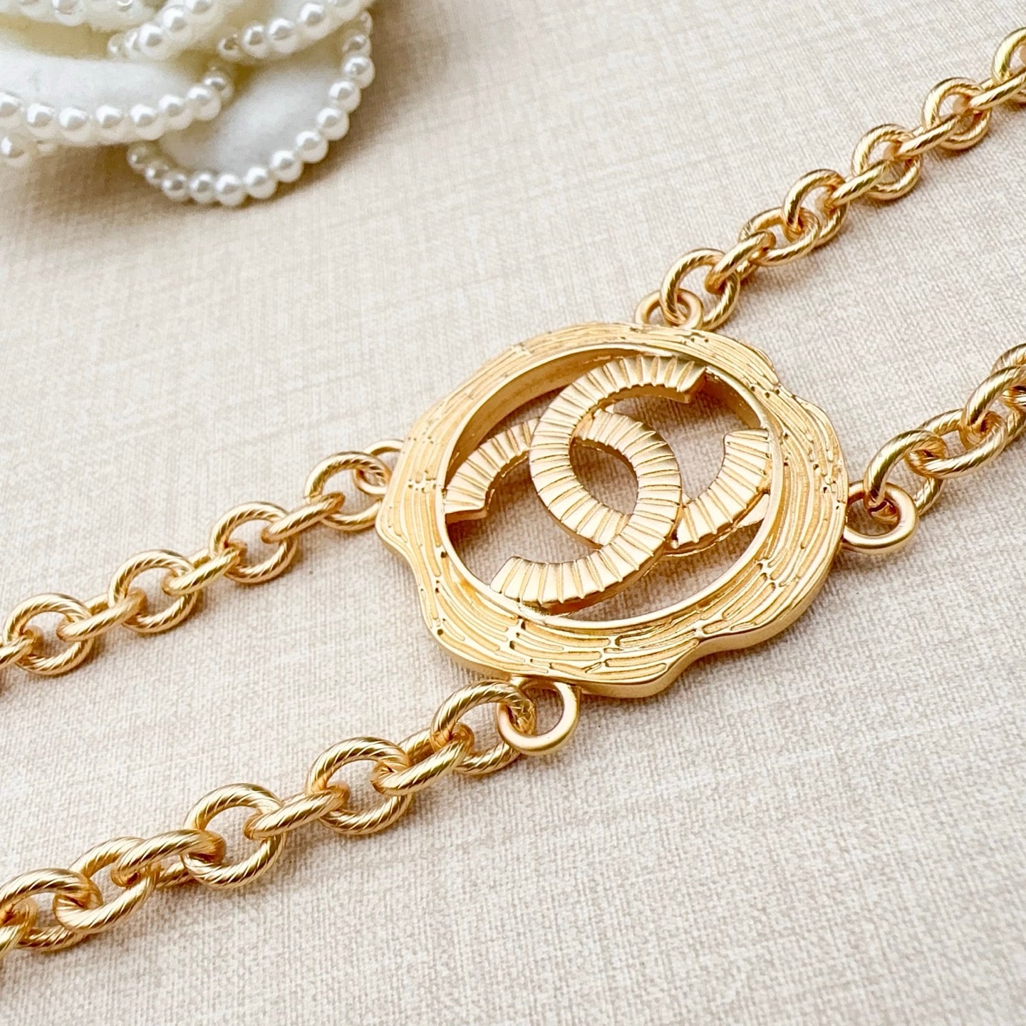 Gold-tone round interlocking CC centerpiece on a chain belt with curb links