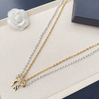 Two-tone belt with silver rhinestone chain, gold chain, and bow charm at end link