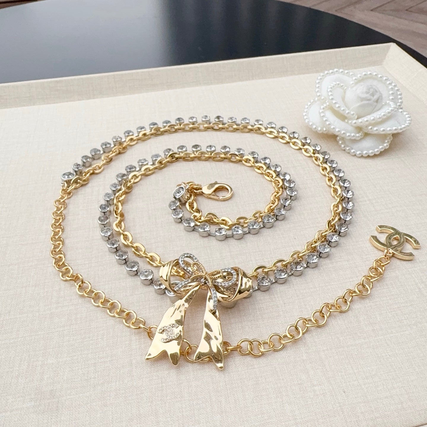 Gold and rhinestone belt with bow charm, CC clasp, and pearl flower accent on chain