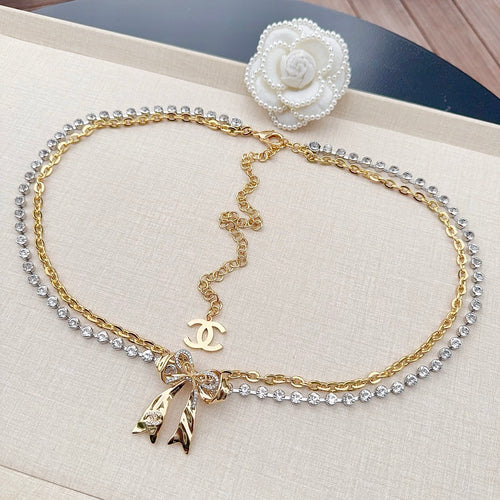 Chanel belt with gold chain, rhinestone stones, bow charm, and pearl flower clasp