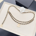 Chanel belt with gold-and-black chain links and white pearl flower embellishment