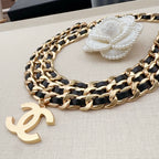 Chanel belt with gold-and-black chain links, gold CC charm, and white flower accent