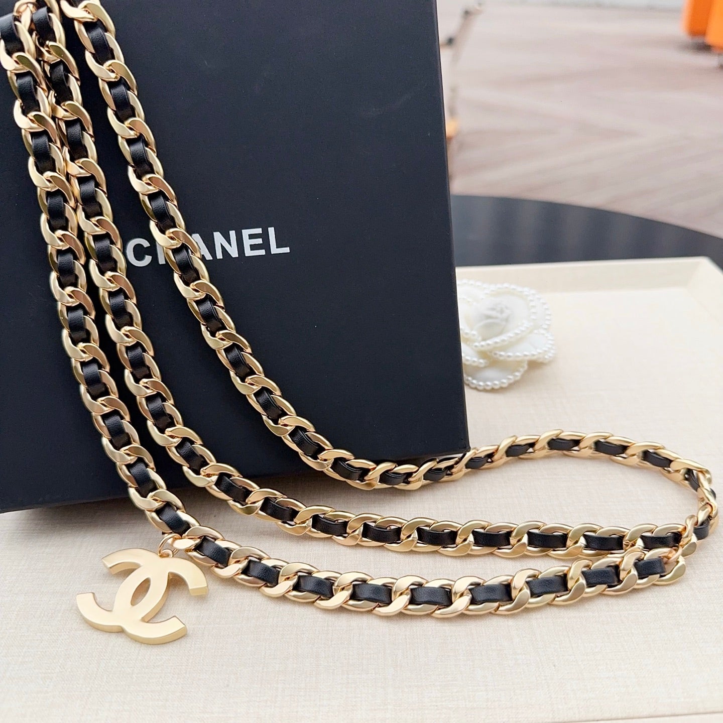Chanel belt strap with gold-and-black chain links and gold CC charm