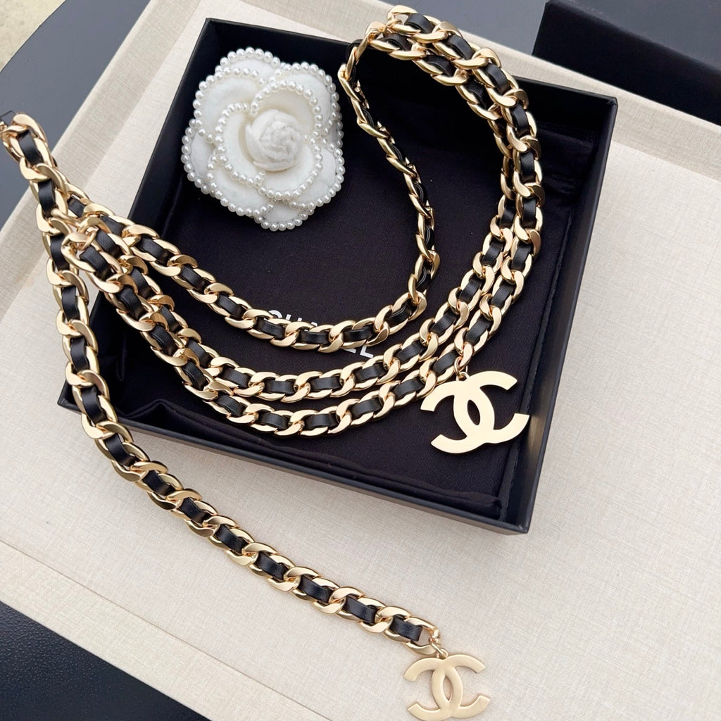 Chanel belt with layered gold-and-black chain links and gold CC charm