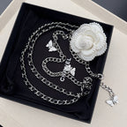 Chain belt in gift box with silver links, butterfly charms, and a white flower clasp.
