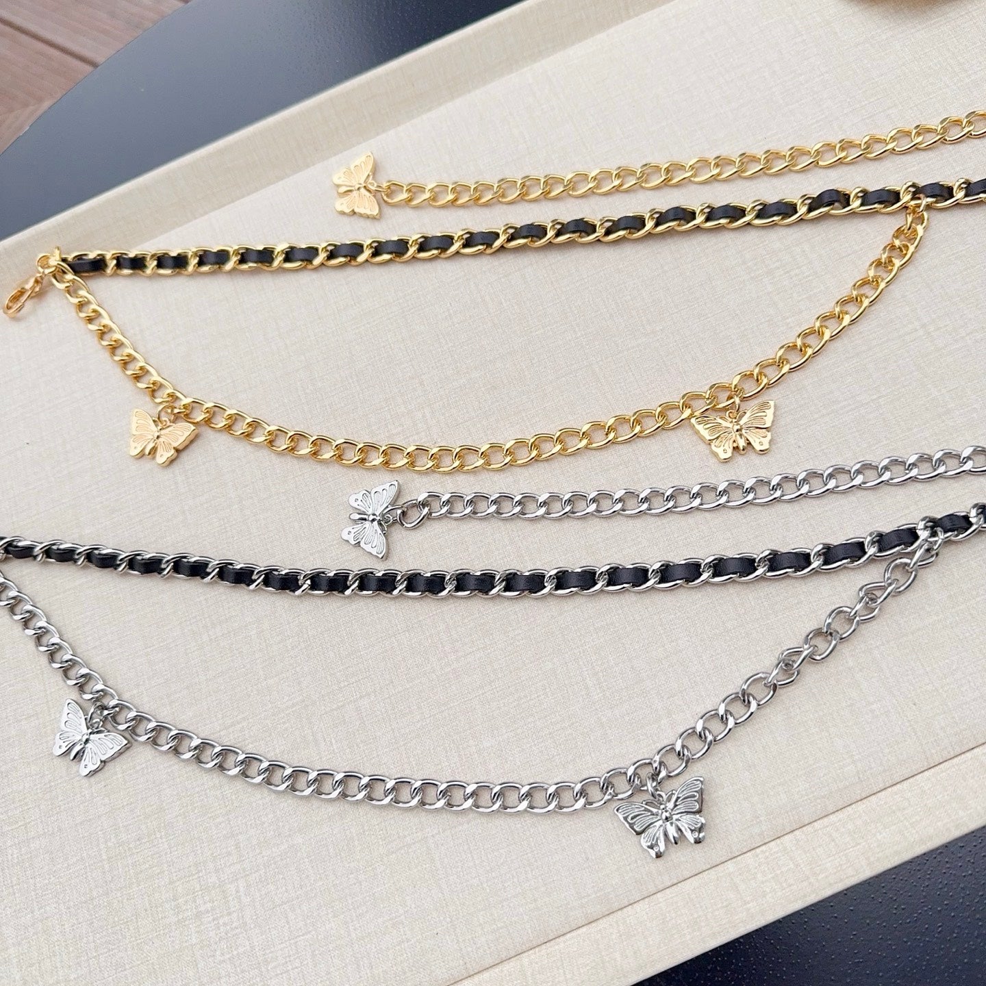 Gold and silver chain belt strands with butterfly charms for a layered look.