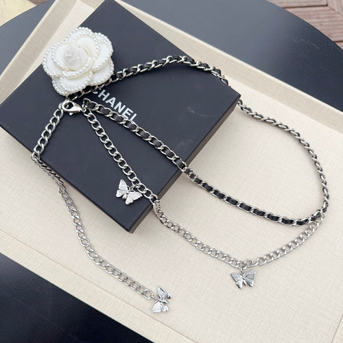 Multi-strand chain belt with silver and dark links, butterfly charms, and a white flower clasp.