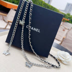 Silver chain belt with butterfly charms on multiple strands, plus a white flower accent.
