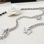 Silver chain belt with butterfly charms and a white flower clasp at the top.