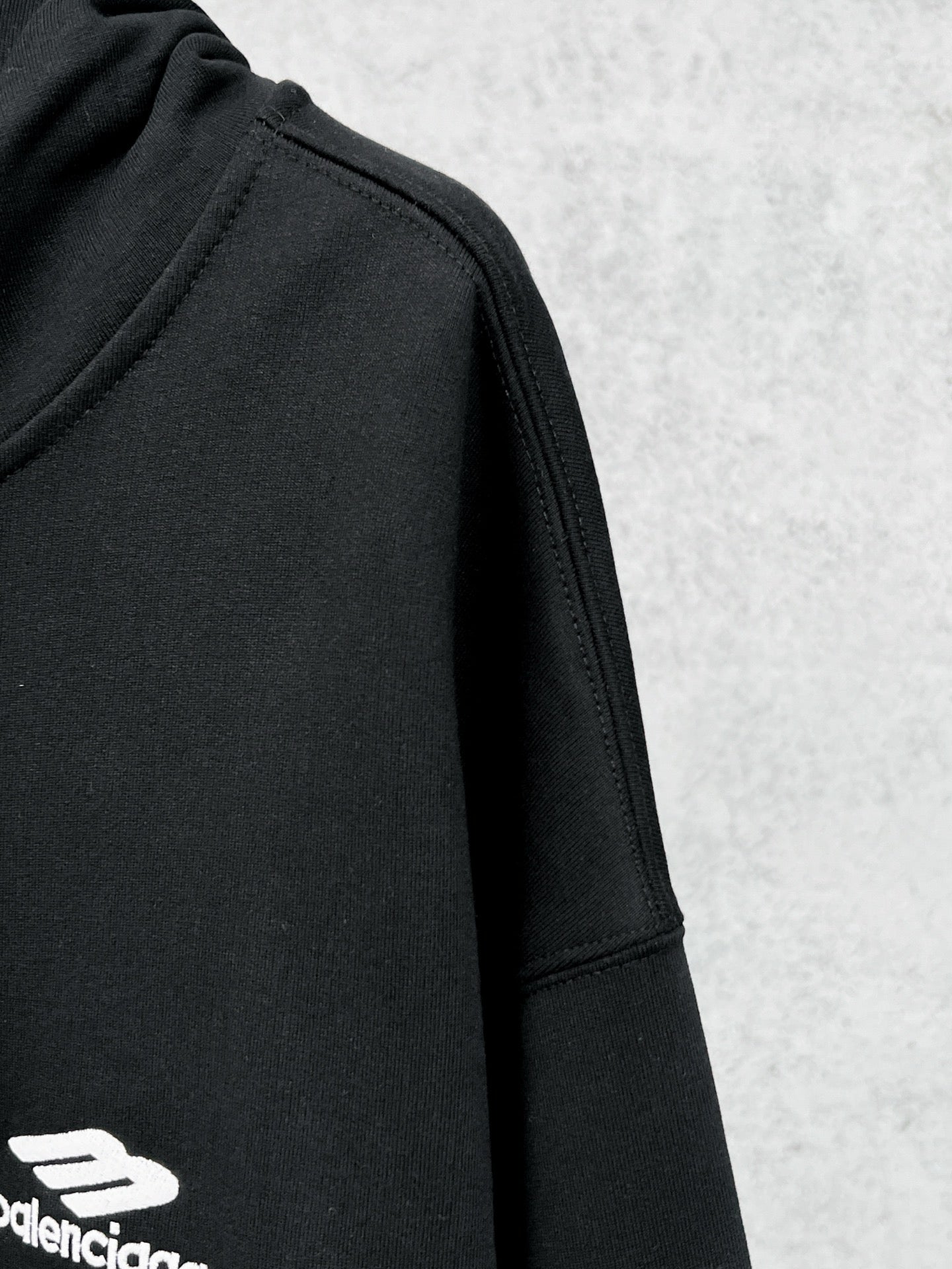 Balenciaga black hoodie sleeve with small side logo print and angled cuff