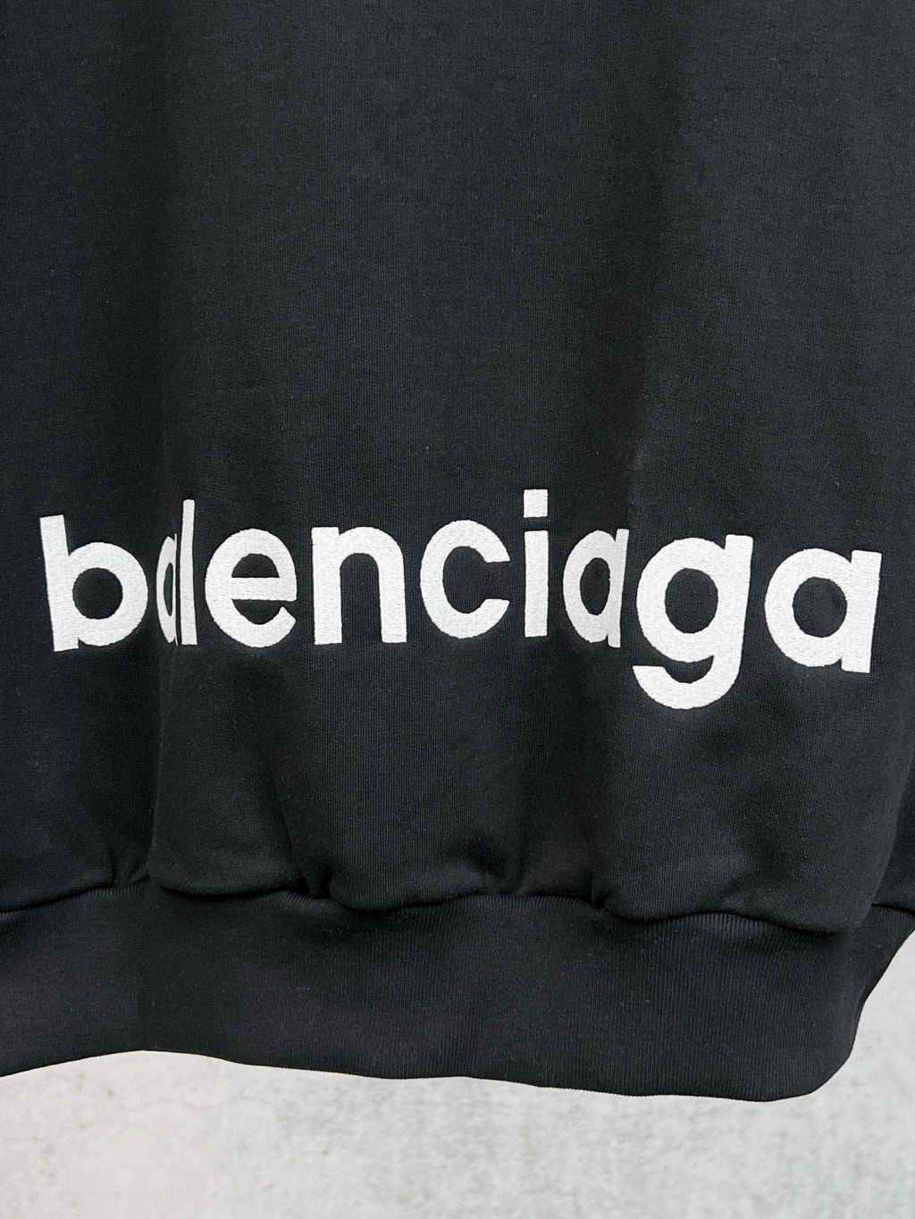 Balenciaga black hoodie with bold 'balenciaga' chest graphic and ribbed hem