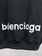 Balenciaga black hoodie with bold 'balenciaga' chest graphic and ribbed hem