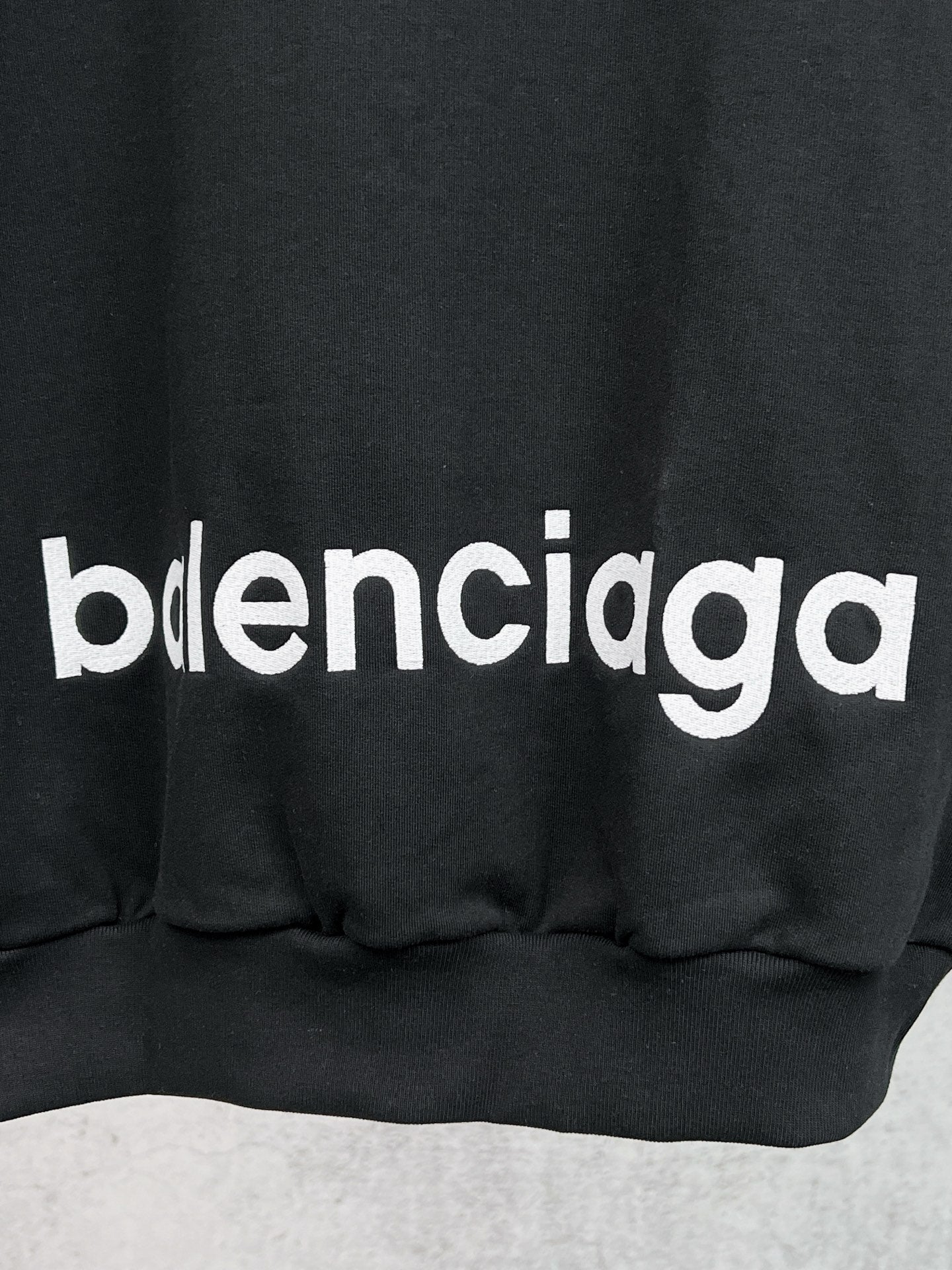 Balenciaga black hoodie with bold 'balenciaga' chest graphic and ribbed hem