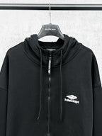 Balenciaga black zip-up hoodie with drawstring hood, central zipper, and chest logo