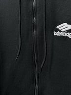 Balenciaga black zip hoodie close-up: center zipper, hood strings, chest logo