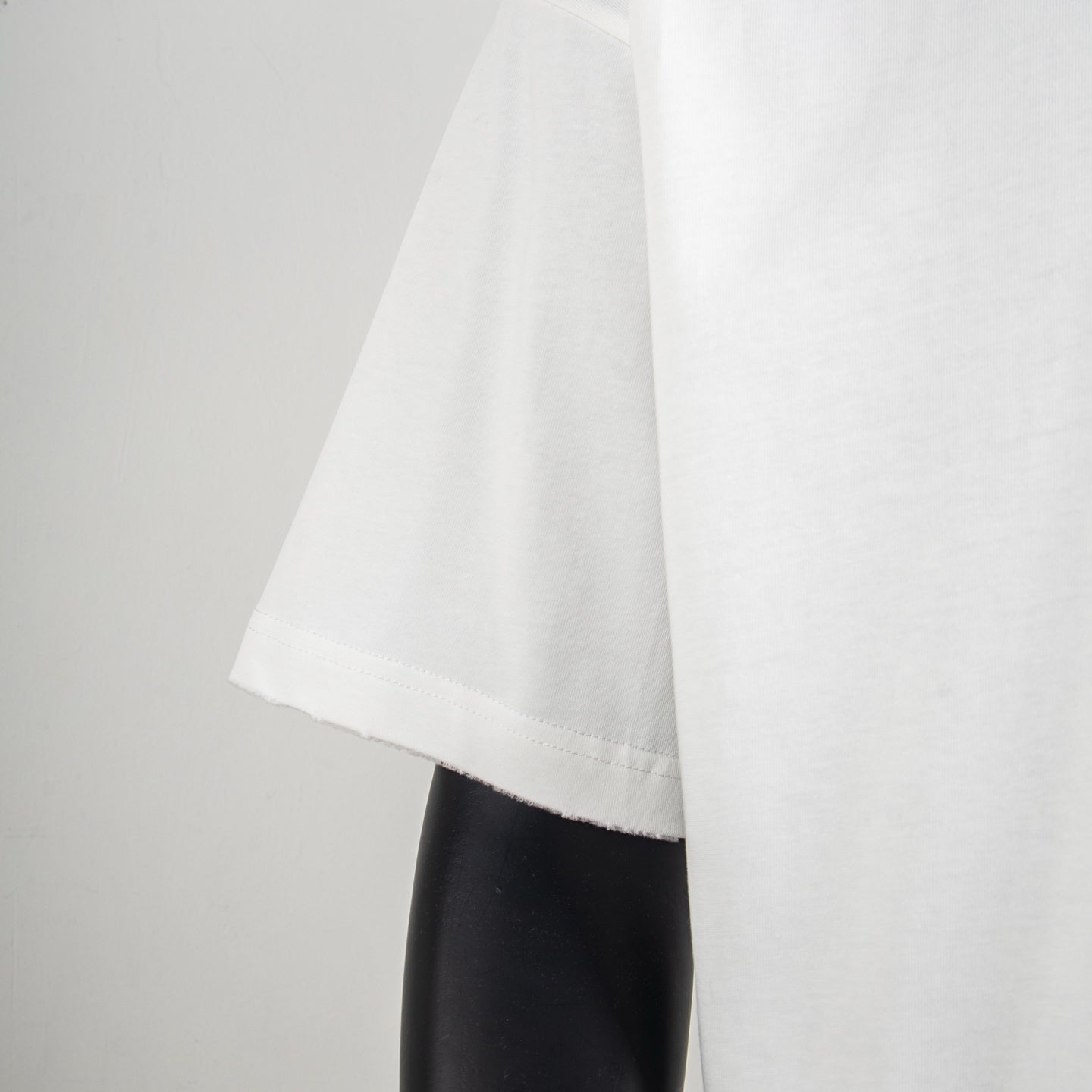 White short-sleeve T-shirt side view with straight hem and visible stitching