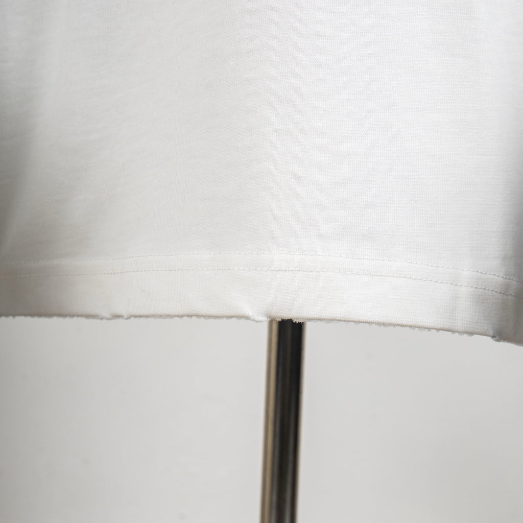 White T-shirt bottom hem with visible seam stitching