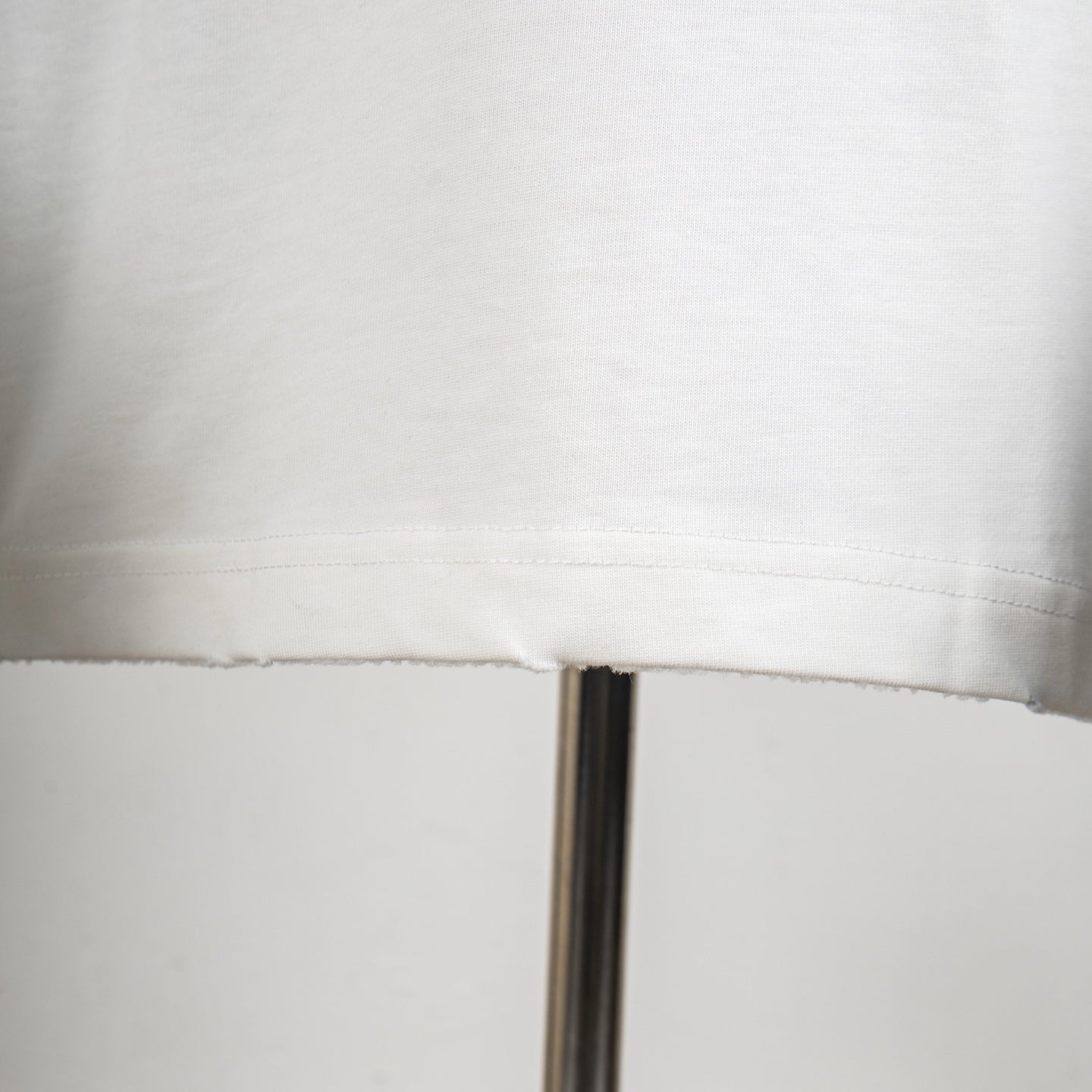 White T-shirt bottom hem with visible seam stitching