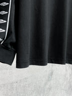 Black long-sleeve shirt hem with white Balenciaga logo stripe sleeve detail