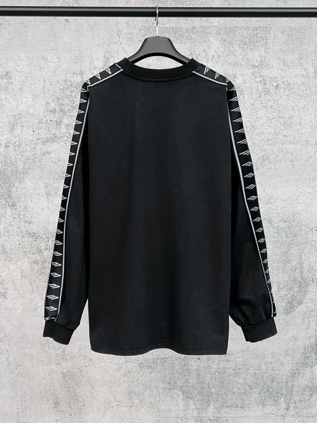 Long-sleeve black shirt with white Balenciaga logo stripe detail on sleeves