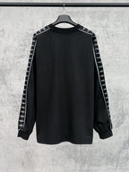 Long-sleeve black shirt with white Balenciaga logo stripe detail on sleeves