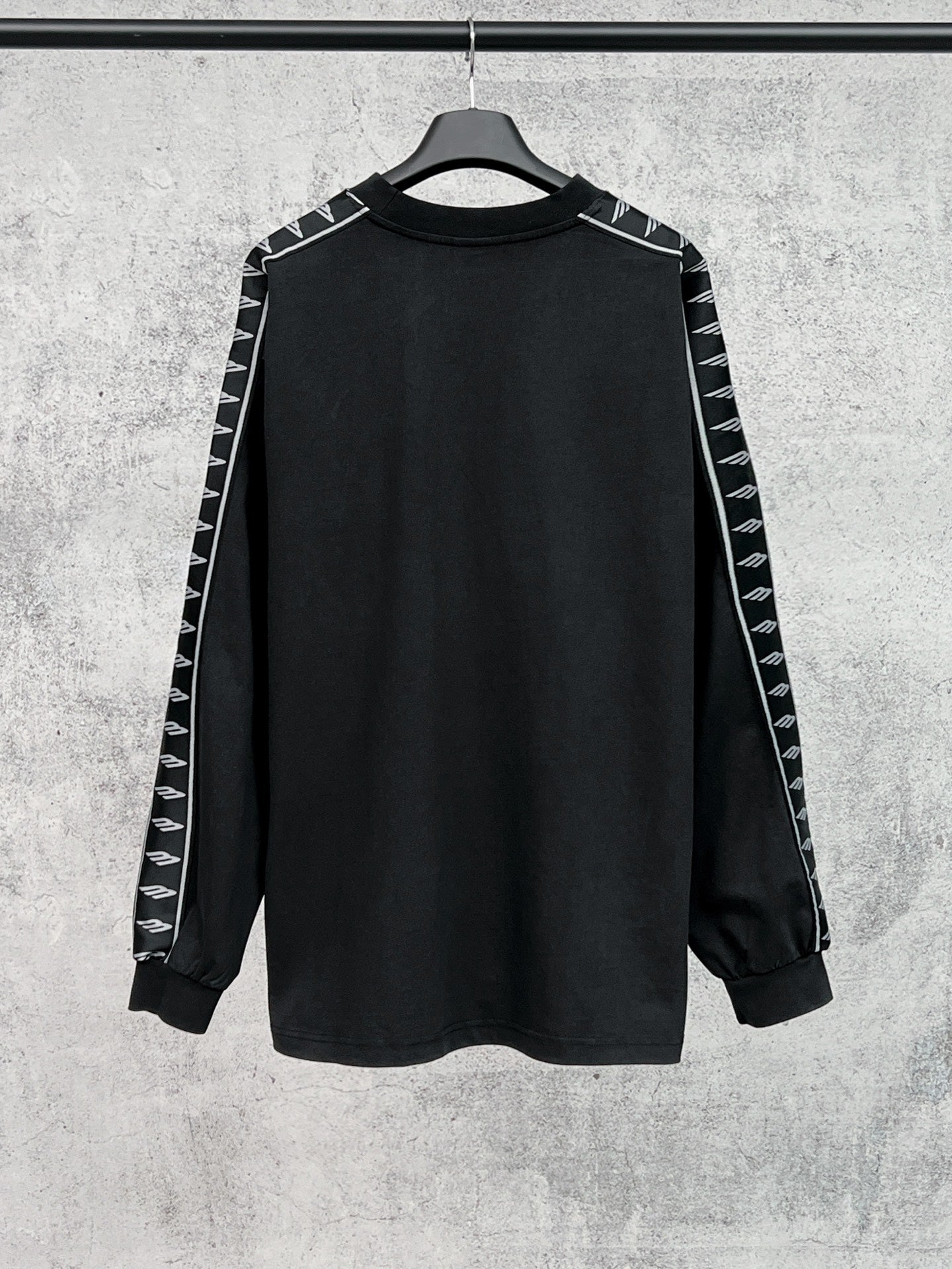 Long-sleeve black shirt with white Balenciaga logo stripe detail on sleeves
