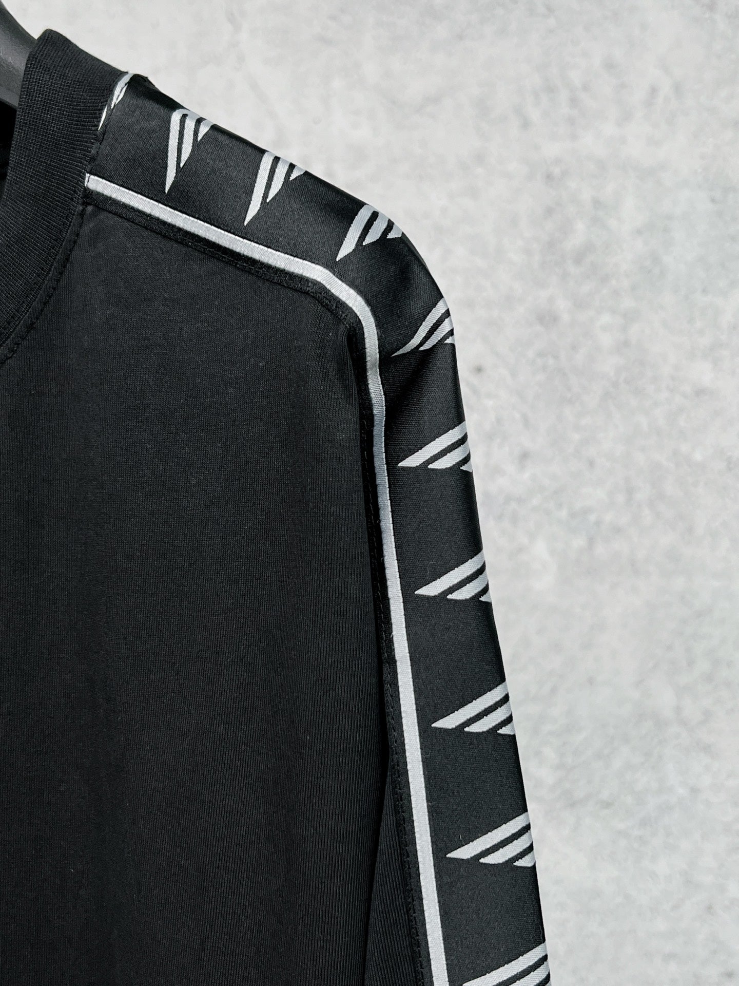 Long-sleeve black shirt with white Balenciaga logo stripe on shoulder and cuff