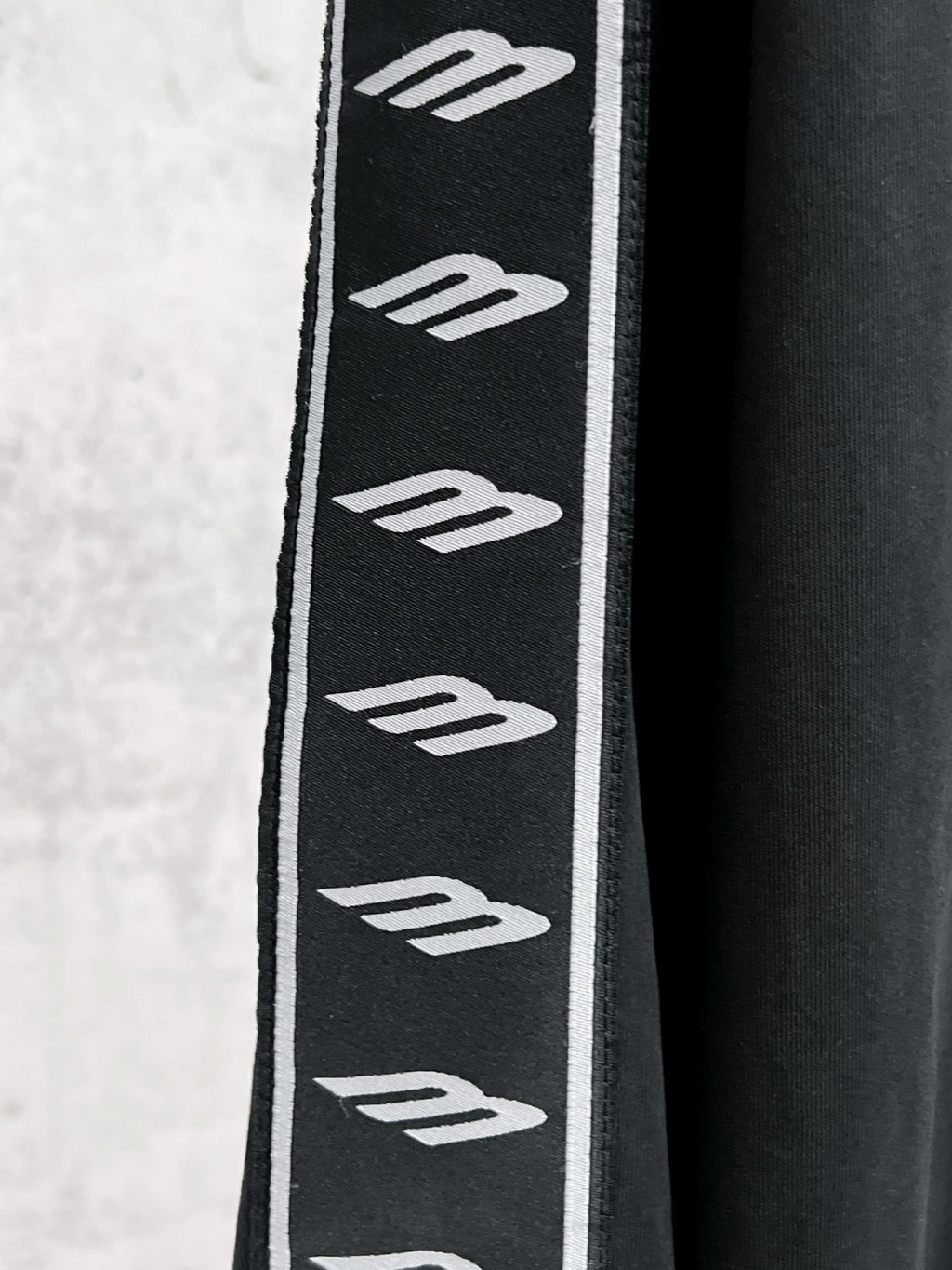 Black sleeve panel with repeating white Balenciaga logo stripes