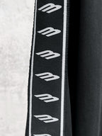 Black sleeve panel with repeating white Balenciaga logo stripes