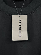 Black long-sleeve shirt neck label on a hanging tag marked Balenciaga