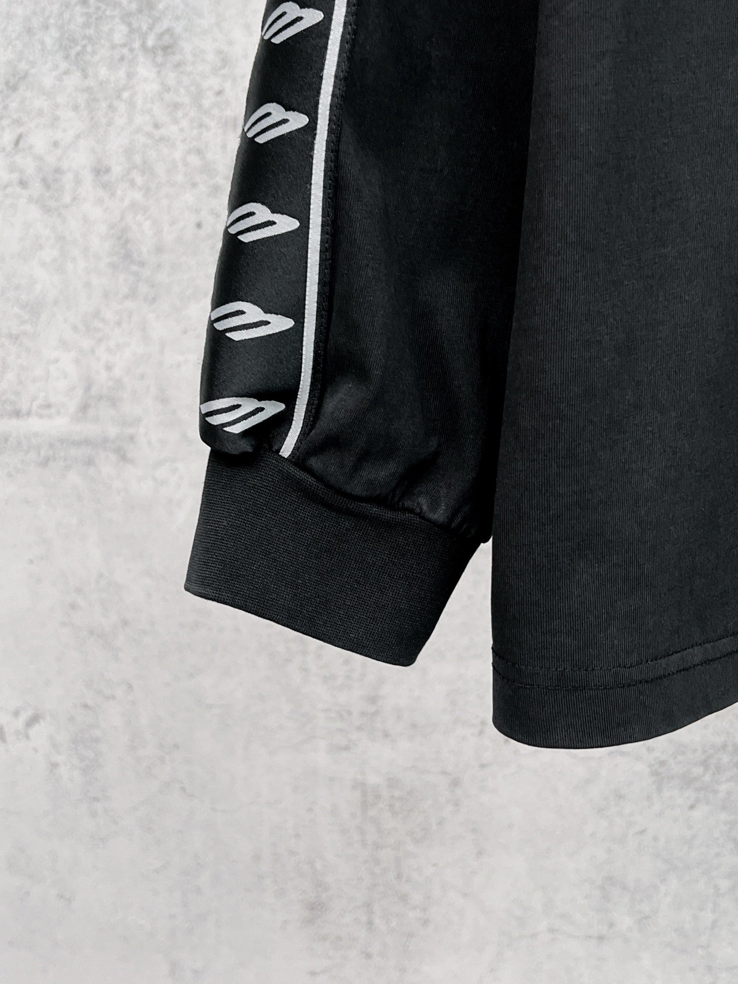 Black long-sleeve shirt cuff with white Balenciaga logo stripe sleeve
