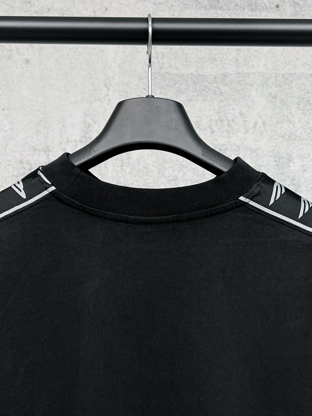 Black long-sleeve shirt collar with white Balenciaga logo stripe on shoulders