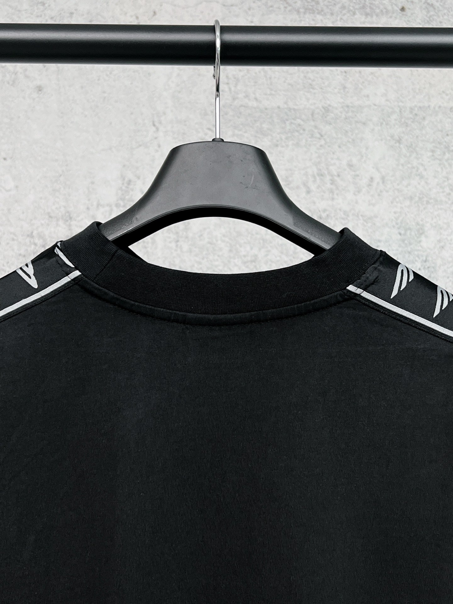 Black long-sleeve shirt collar with white Balenciaga logo stripe on shoulders