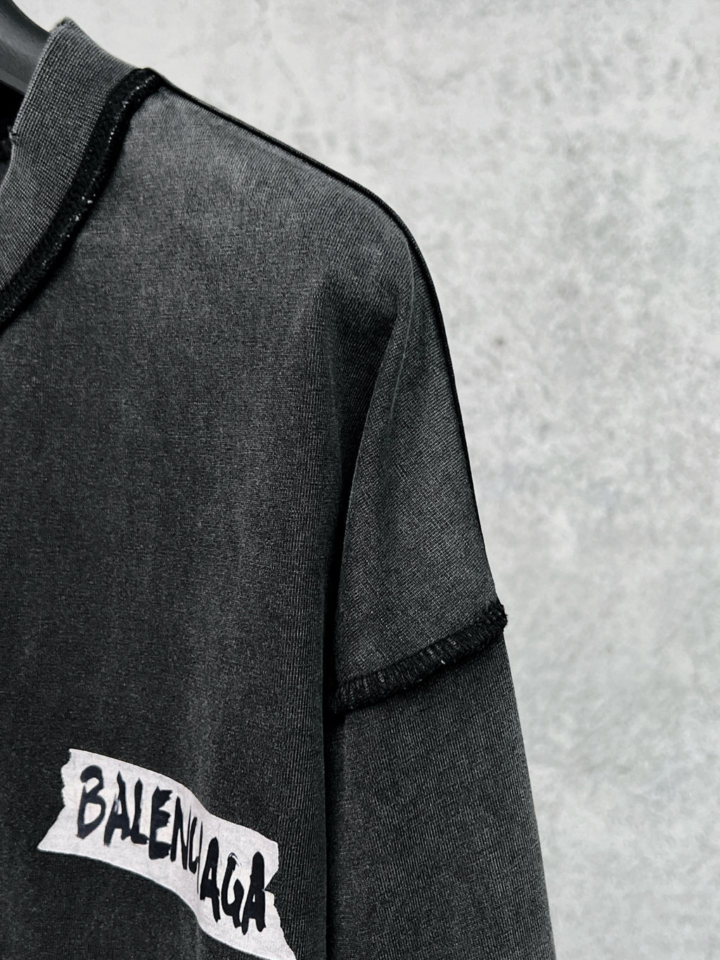 Balenciaga logo patch detail on black long-sleeve T-shirt sleeve