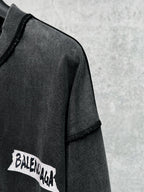 Balenciaga logo patch detail on black long-sleeve T-shirt sleeve