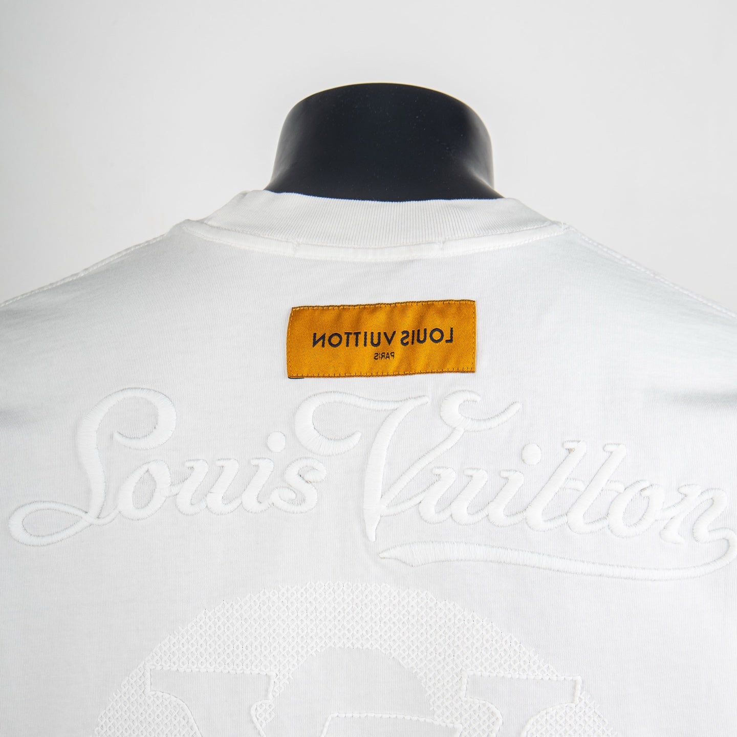 White T-shirt back with cursive logo embroidery and yellow brand label