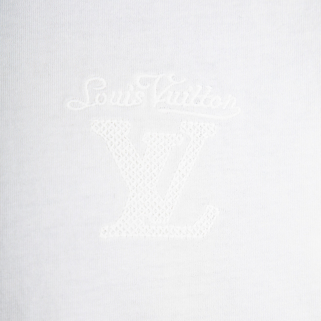 White T-shirt with faint LV-style monogram emblem