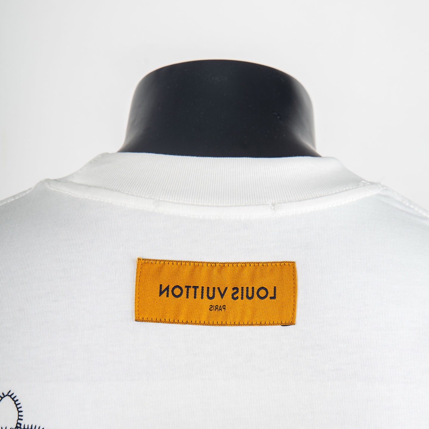 White T-shirt neck label in orange with black text