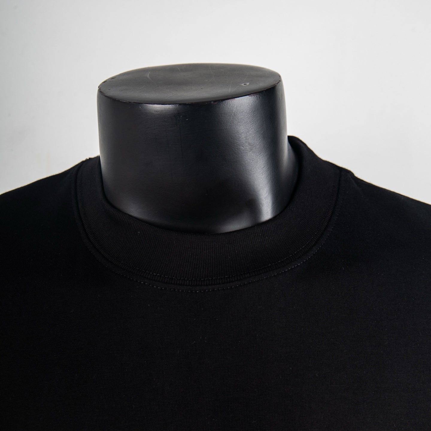 Black crewneck T-shirt collar close-up with ribbed neckline