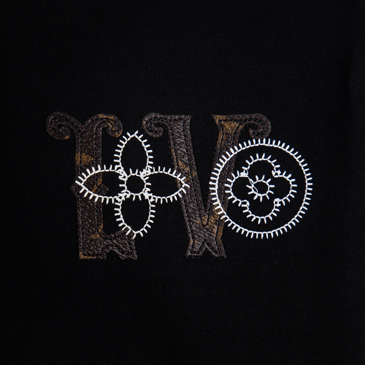 Black T-shirt front close-up of embroidered LV and Paris text
