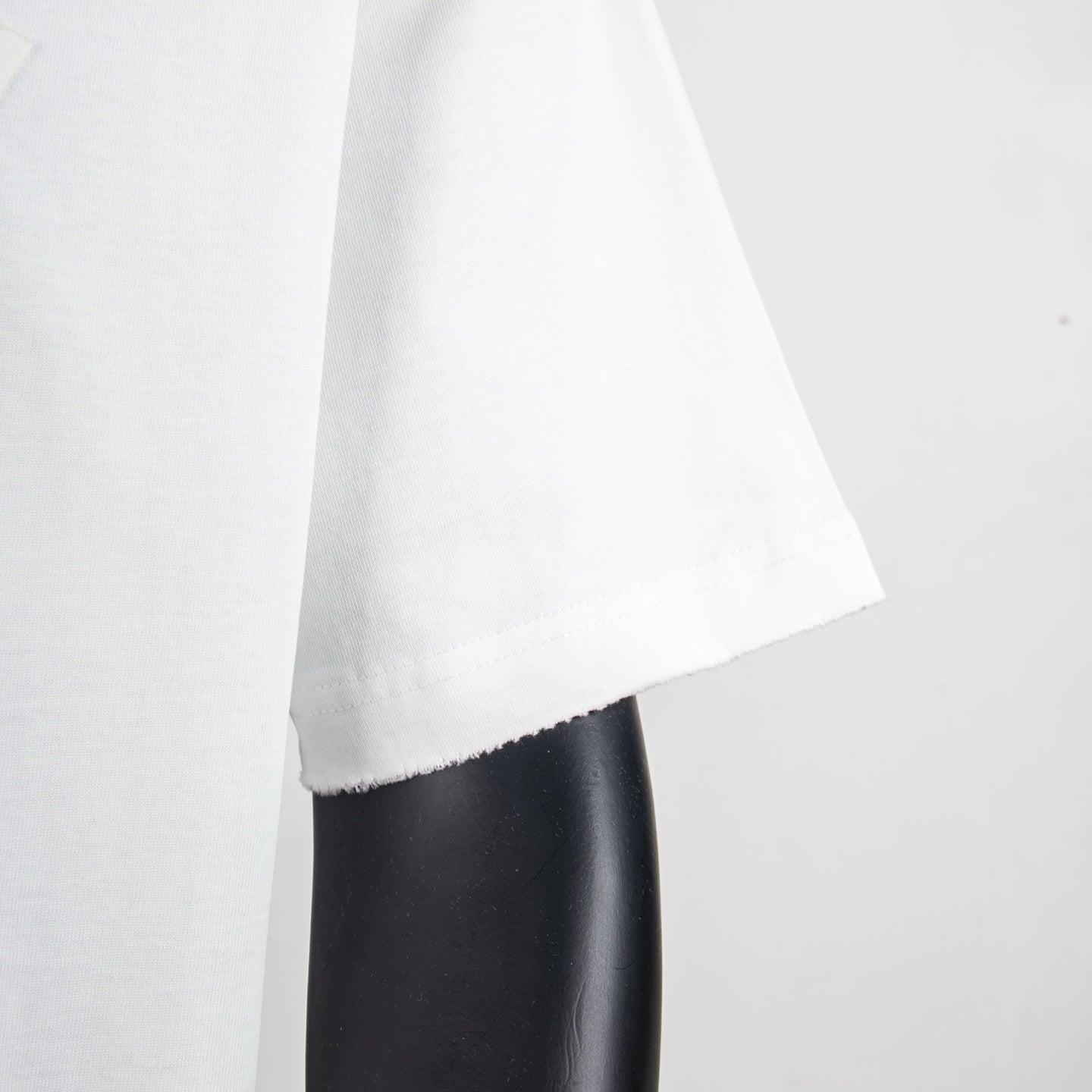 White T-shirt side view with draped fabric and curved hemline