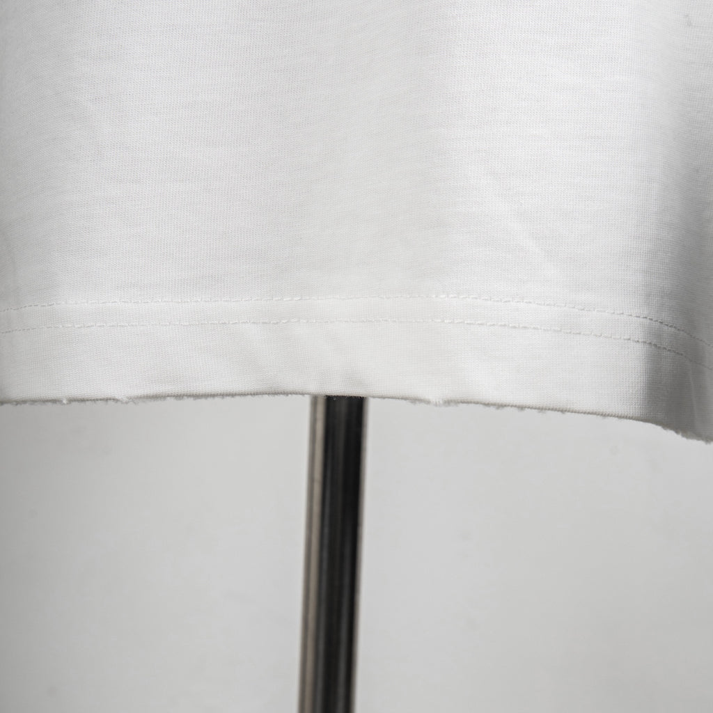 White T-shirt lower hem with visible stitching detail