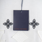 White T-shirt neckline with attached navy tag and fleur-de-lis embroidery