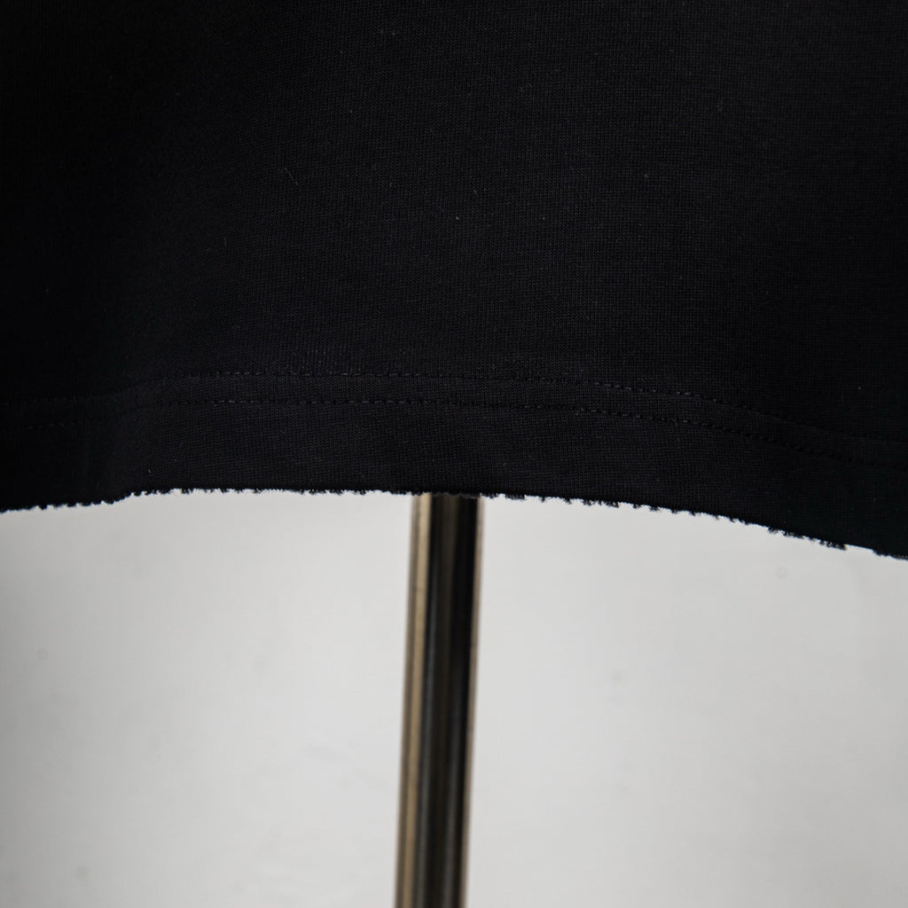 Black T-shirt hem with visible stitching