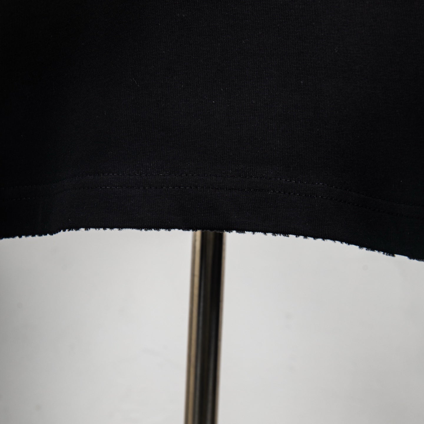 Black T-shirt hem with visible stitching