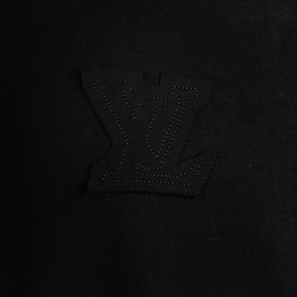 Black T-shirt chest area with embossed logo embroidery detail