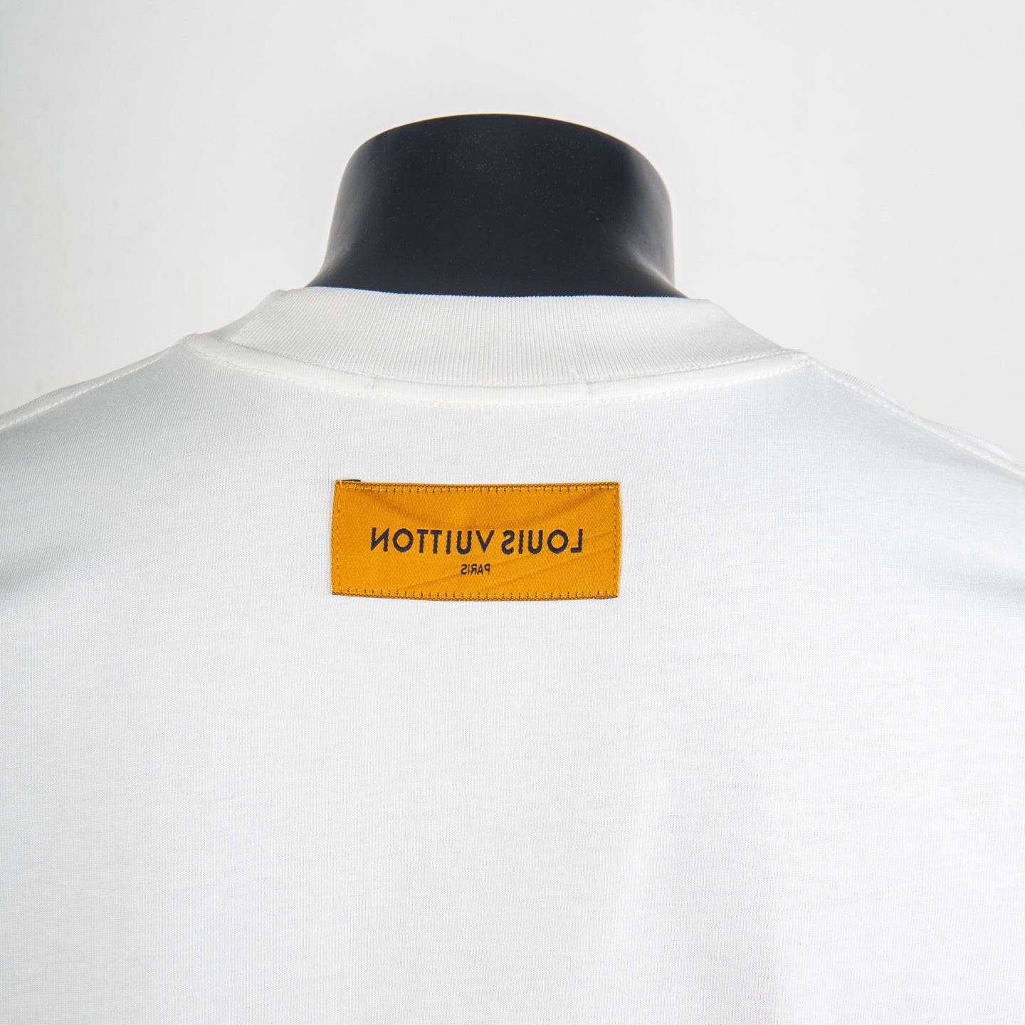 Louis Vuitton white T-shirt with rectangular orange back neck label.