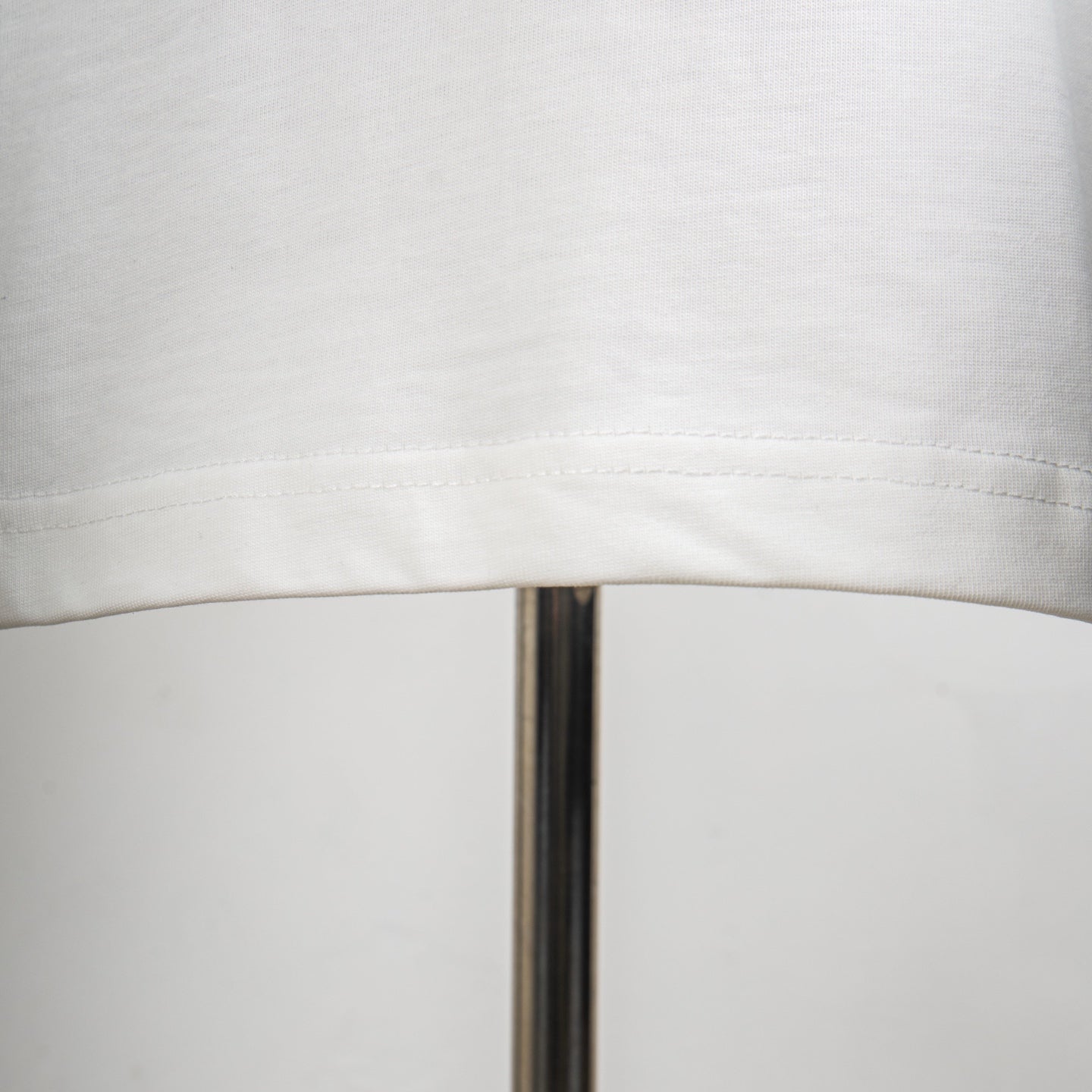 Louis Vuitton white T-shirt hem stitching seam detail.