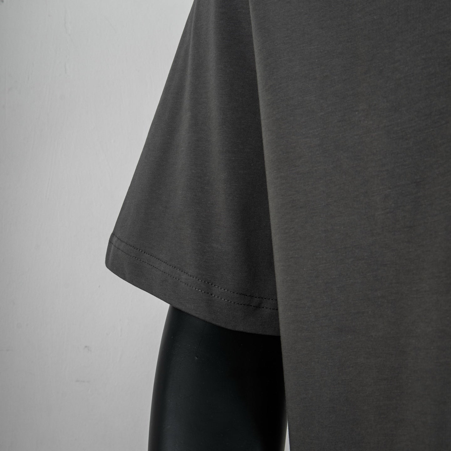 Dark gray short-sleeve T-shirt with curved hem and visible side seam